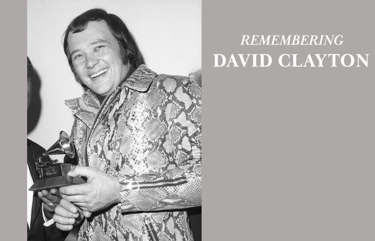 Memorial graphic honoring David Clayton: black-and-white photo of a smiling man holding a trophy, wearing a snakeskin jacket, with 'Remembering David Clayton' text on the right.